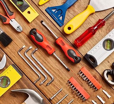 A home remodeling contractor working on a residential handyman job — mid-task, hands, tools and the work itself in sharp focus, the rest of the space softly out of focus